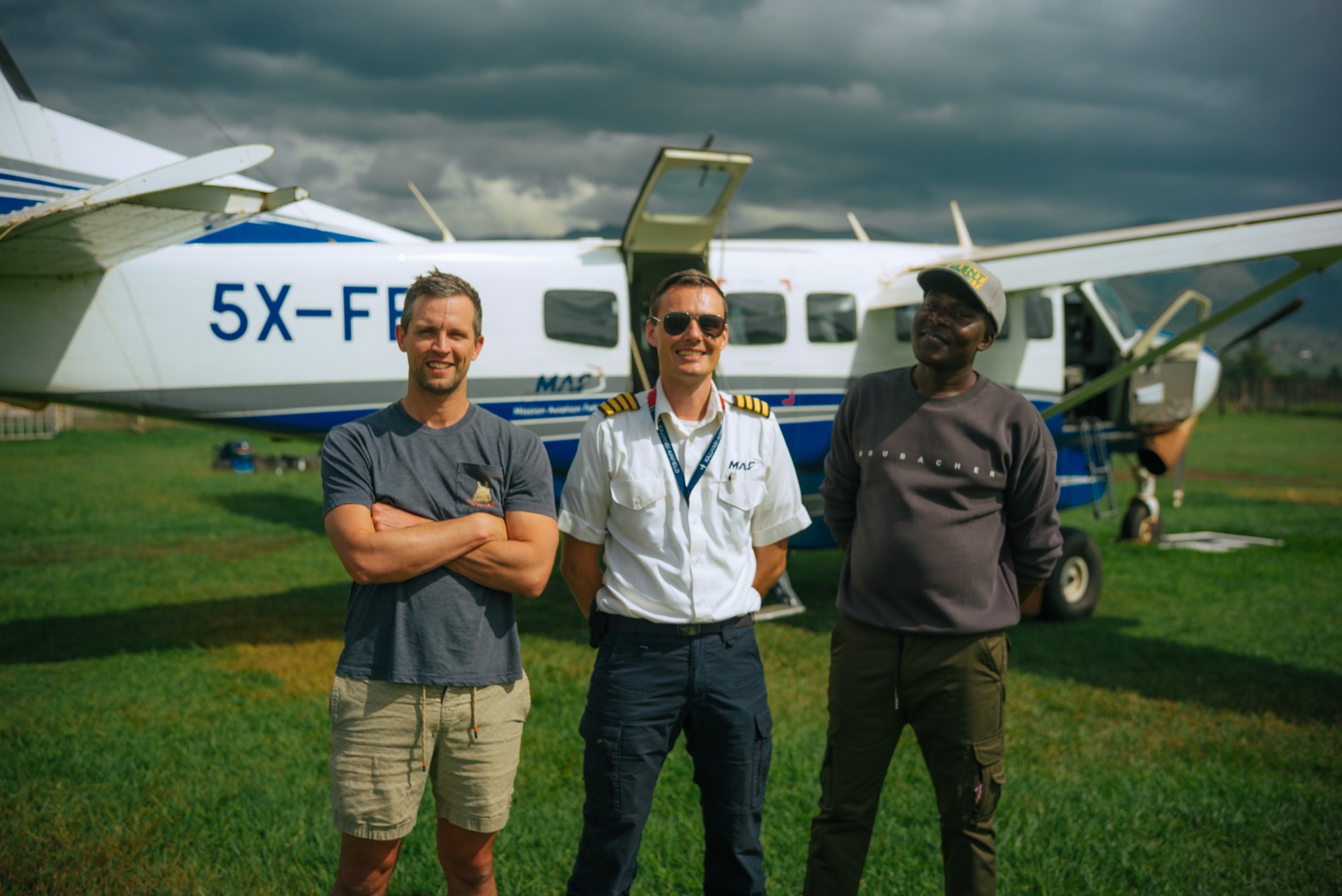 The crew and pilots at the bush plane on a grass airstrip
