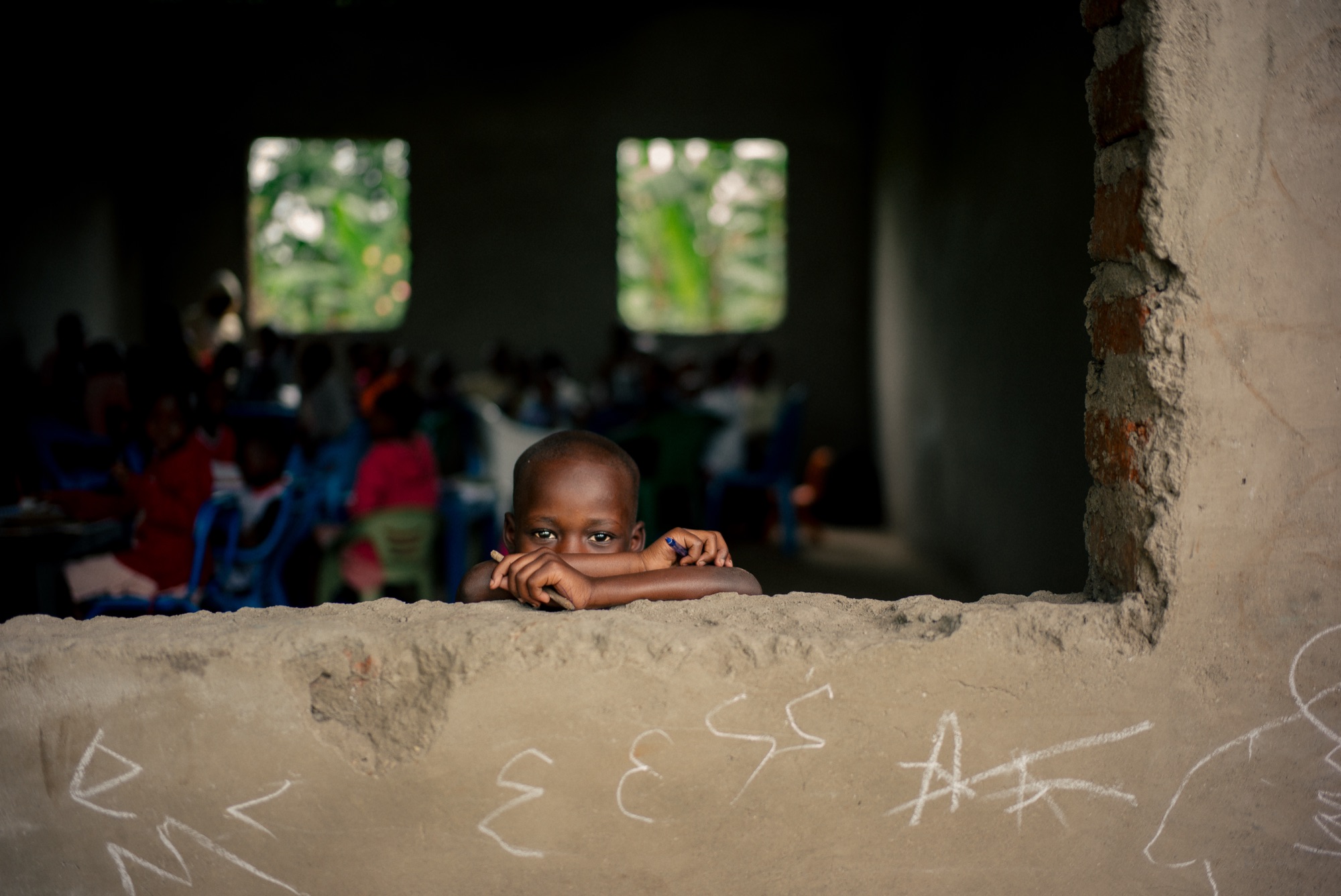 A child at the window of the school mid-build, Uganda