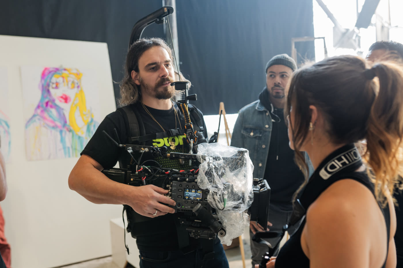 Camera operator carrying the painted portrait