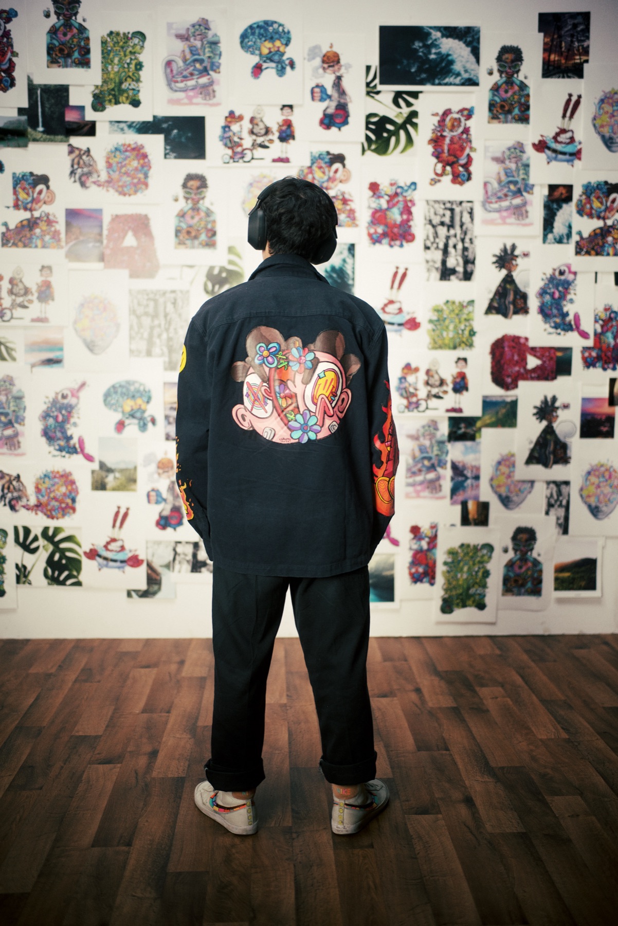 Gawx Art facing his wall of artwork on set
