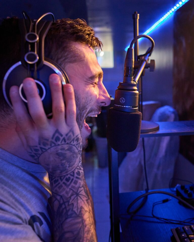 A vocalist at full volume into a Turnstile Audio mic, blue studio light